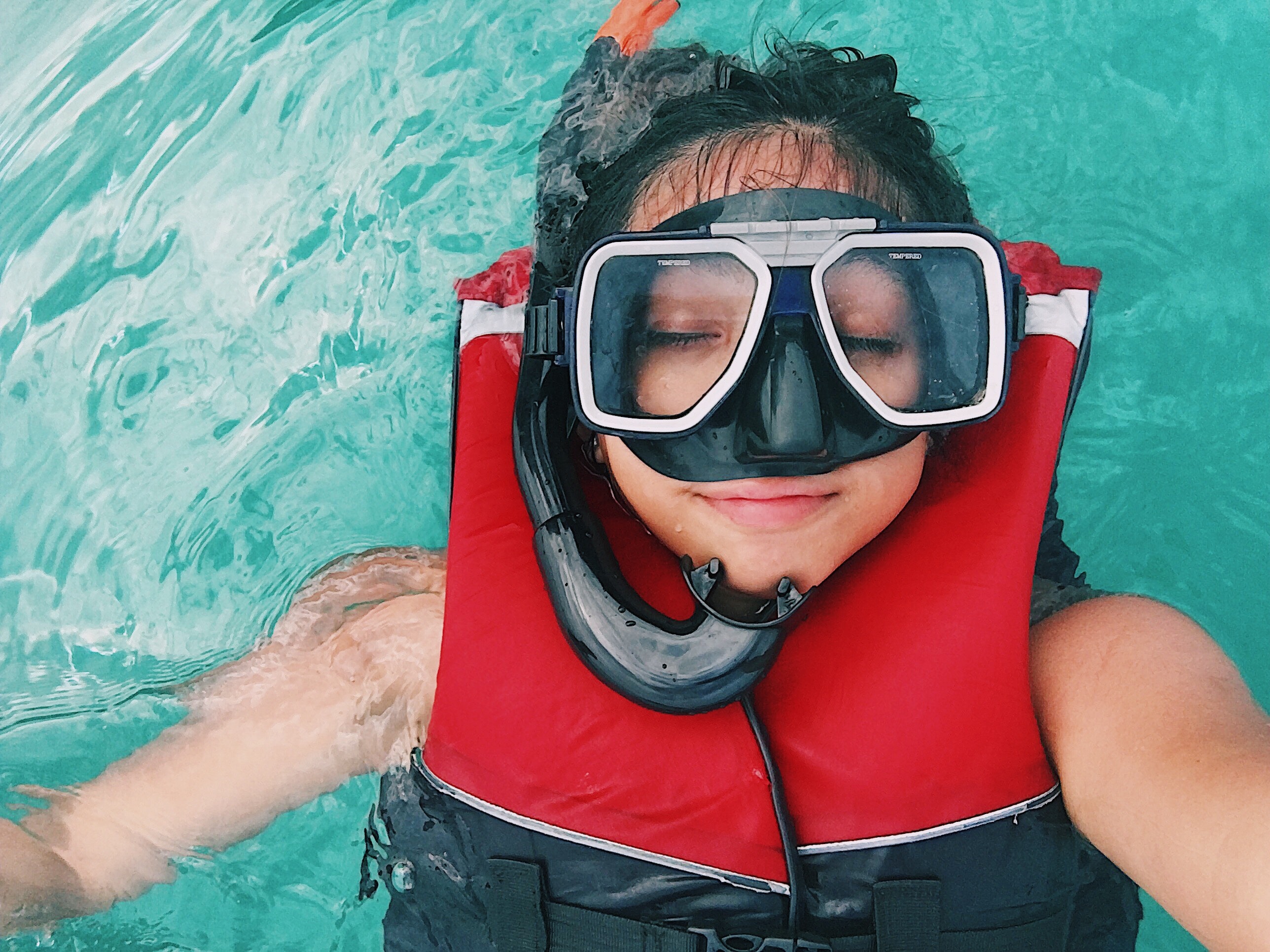 a-person-wearing-red-and-black-life-vest-and-goggles-while-2403840